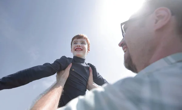 Stylized photo.a happy father holds his son in his hands — Stock Photo, Image