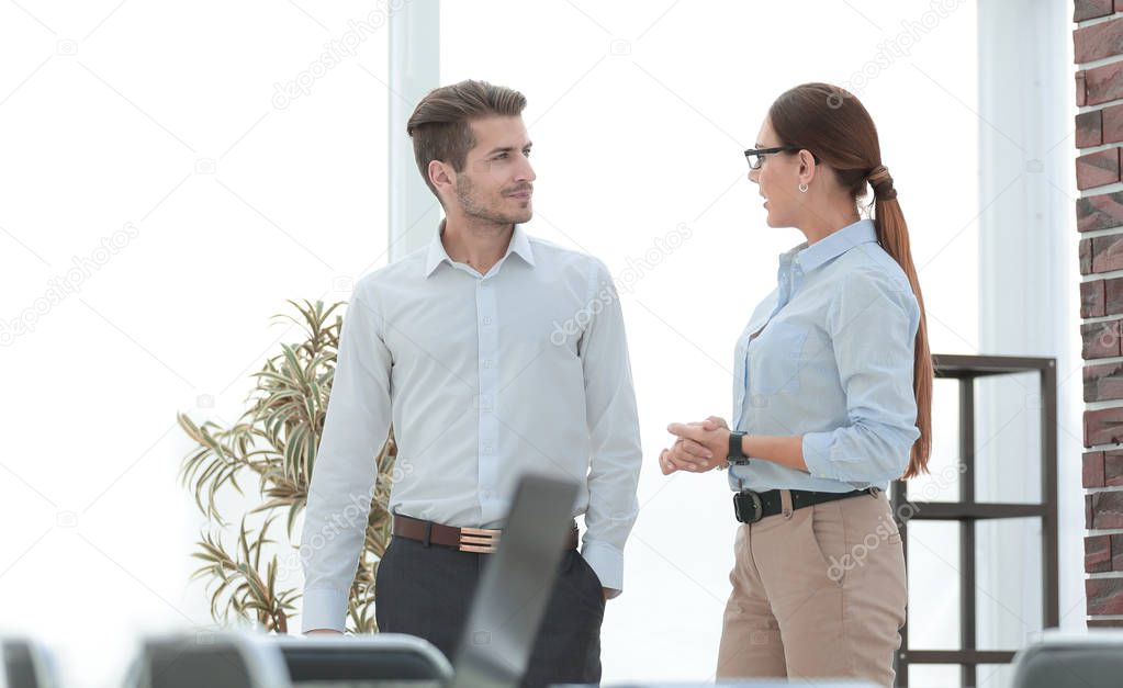 Manager and employee talking standing in the office