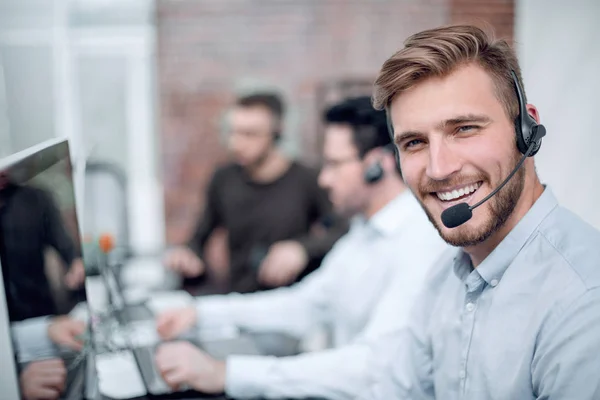 Personal sonriente del centro de negocios sentado en el escritorio — Foto de Stock