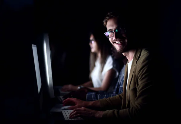 smiling employee working in the office at night