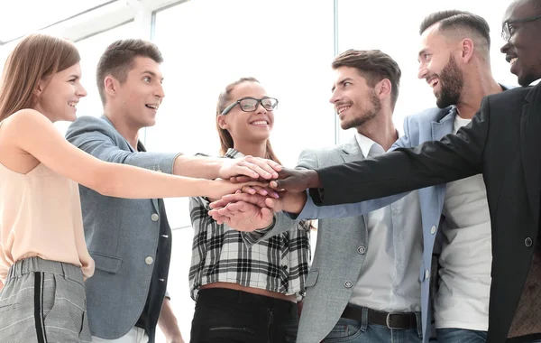 Groep van mensen uit het bedrijfsleven stapelen zich op hun handen samen in de w — Stockfoto