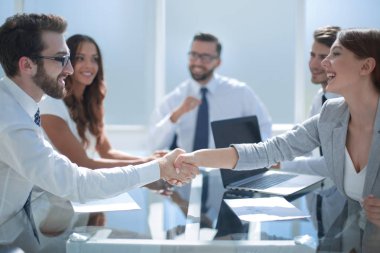 iş adamı ve iş kadını bir toplantıda tokalaşırken.