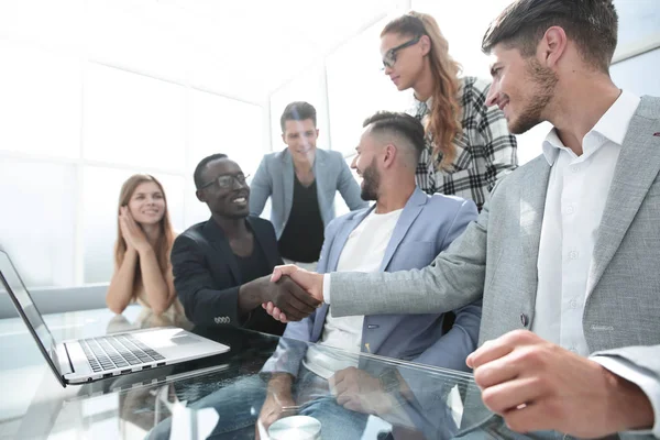 Colegas multinacionales en la oficina sonriendo a la mesa — Foto de Stock