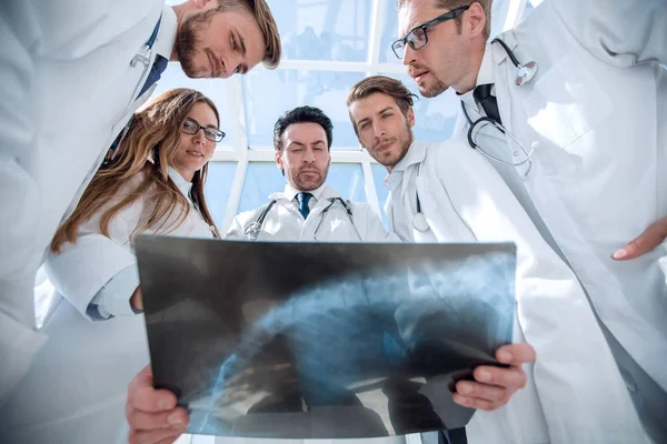 Läkare kollegor ser på röntgen av patienten — Stockfoto