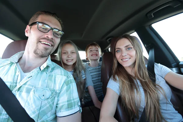 Närbild. lycklig familj i en bekväm bil — Stockfoto