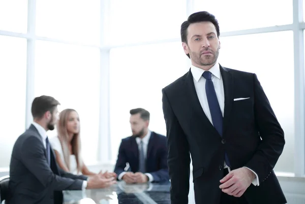 Серйозний бізнесмен стоїть в сучасному офісі . — стокове фото