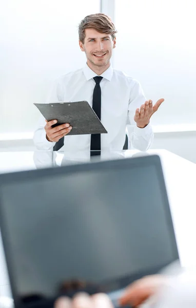 Hombre de negocios con un portapapeles sentado en la mesa de negociaciones . —  Fotos de Stock