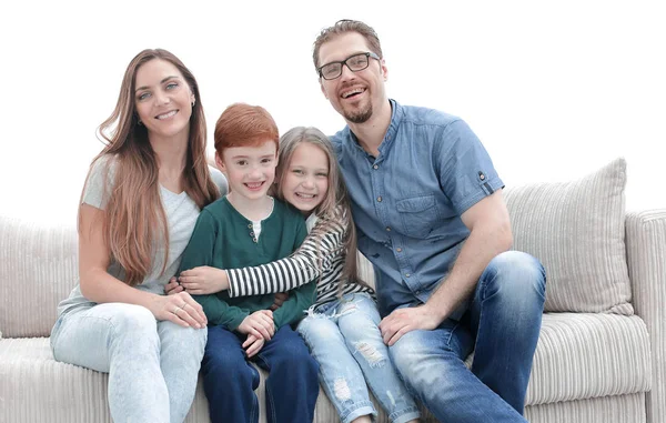 Familj med två barn som sitter i soffan i vardagsrummet — Stockfoto