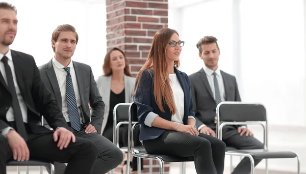 Gelukkig business team zitten in een rij op kantoor. — Stockfoto