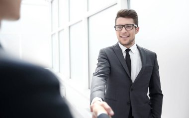 Yönetici müşteriyi el sıkışarak selamlar.
