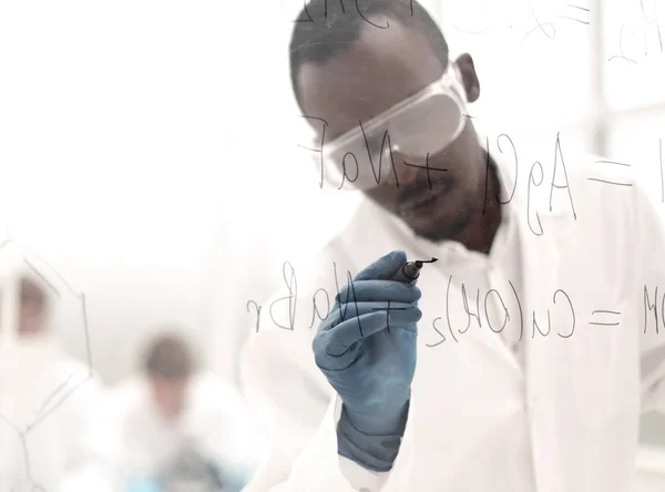 Επιστήμονας που γράφει χημικό τύπο σε ένα γυάλινο πίνακα — Φωτογραφία Αρχείου