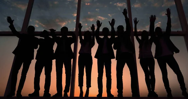 Silueta de un grupo de empresarios levantando la mano — Foto de Stock