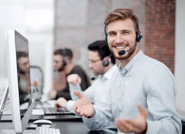 Vriendelijk personeel met een headset op de werkplek in het business center — Stockfoto