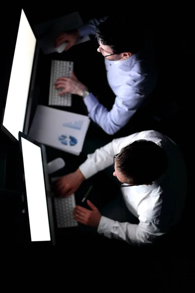 Δύο επιχειρηματιών κάνει μια οικονομική έκθεση, το βράδυ. — Φωτογραφία Αρχείου