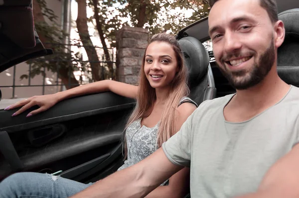 Homem bonito sentado ao volante de um carro de luxo . — Fotografia de Stock