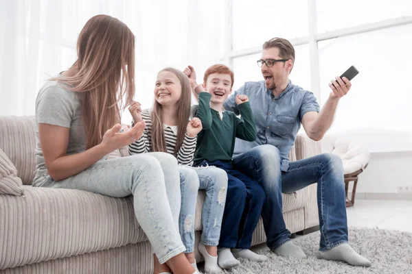 Щаслива сім'я сидить дивитися телевізор у своєму будинку — стокове фото