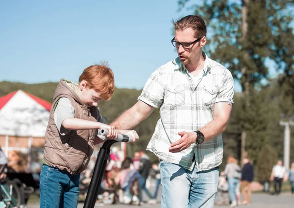 Vader leert zoon te rijden een mini-hoverboard in het Park — Stockfoto