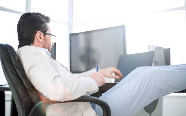 Geschäftsmann sitzt während einer Arbeitspause am Schreibtisch — Stockfoto