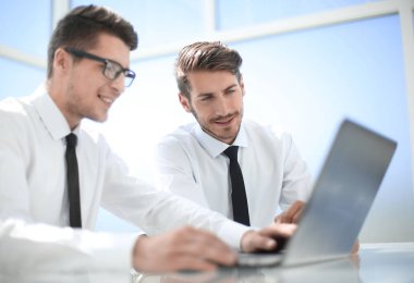 Ofiste bir toplantıda bir masada oturan iş adamları.