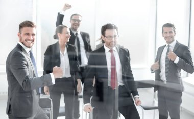 Muzaffer iş ekibi konferans odasında duruyor.