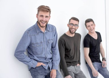 üç kişi duvara yaslanmış gülümseyen