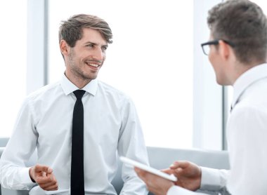 Yeni bilgi tartışırken bir dijital tablet ile iki çalışanı