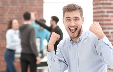 Yakışıklı işadamı zaferi kutluyor. Mutlu bir şekilde bağırıyor.