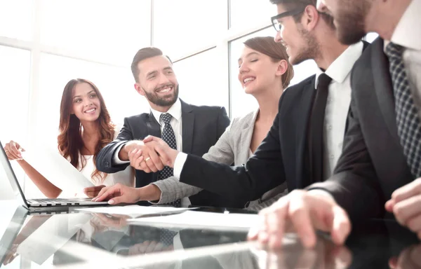 Empresários aperto de mão sentados à mesa das negociações — Fotografia de Stock
