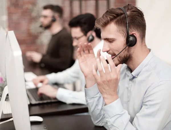 Funcionários com um fone de ouvido no local de trabalho no centro de negócios — Fotografia de Stock