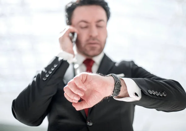 Geschäftsmann blickt auf eine Armbanduhr. — Stockfoto