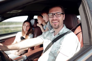 Yan görüş. Mutlu baba araba kullanıyor.