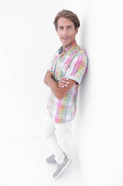 duvara yaslanmış ciddi genç adam