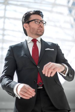 Yakışıklı iş adamı saatine bakıyor.