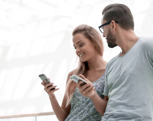 Joven pareja leyendo mensaje de texto en el teléfono inteligente — Foto de Stock