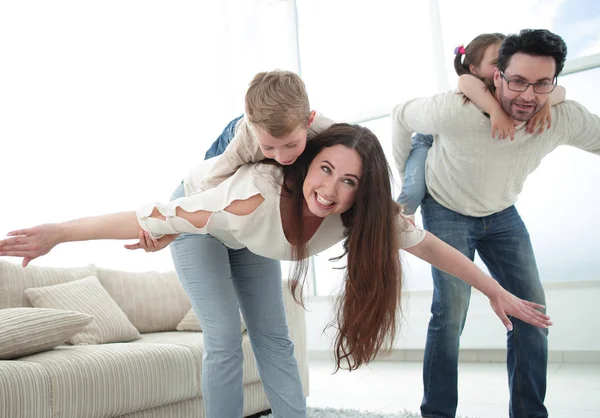 Pais amorosos brincando com crianças em sua casa — Fotografia de Stock