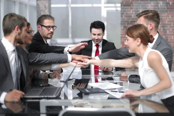Бізнес-колеги працюють в офісі, тримаючи руки разом — стокове фото