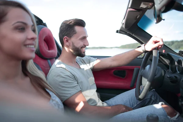 Närbild.leende par sitter i en cabriolet bil — Stockfoto