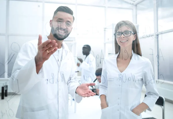 Man and woman in white lab coats — Stock Photo, Image