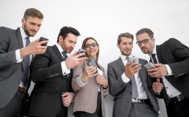 İş ekibi akıllı telefonlarının ekranlarına bakıyor.