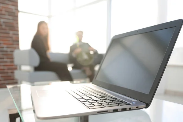 Concentre-se no laptop na mesa. Pessoas desfocadas em segundo plano . — Fotografia de Stock