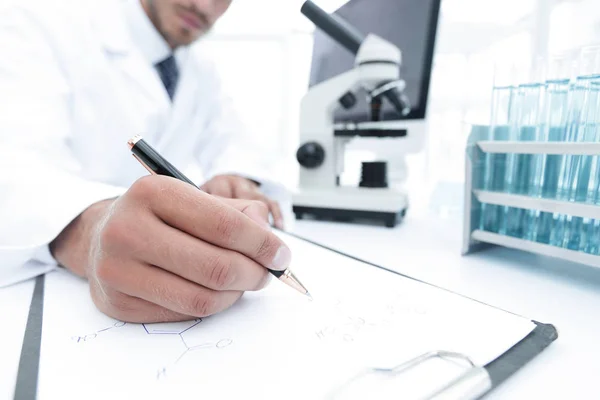 Scientist makes a note of experiment in the laboratory — Stock Photo, Image