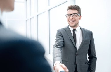 Yönetici müşteriyi el sıkışarak selamlar.