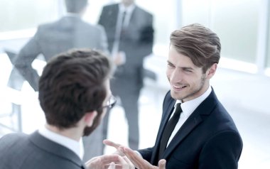 iş arkadaşları ayakta busines lobisinde konuşuyor