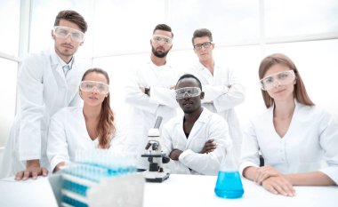 Grup genç başarılı bilim adamı kamera için poz