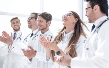 Bir grup başarılı doktor alkışlıyor.