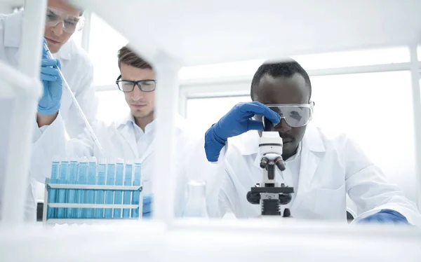 Gruppo di scienziati che lavorano con i liquidi in laboratorio — Foto Stock