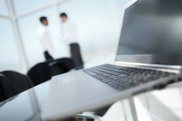 Close-up of office desk with business team behind — Stock Photo, Image