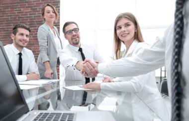 Ofis masaları el sıkışan iş adamları.