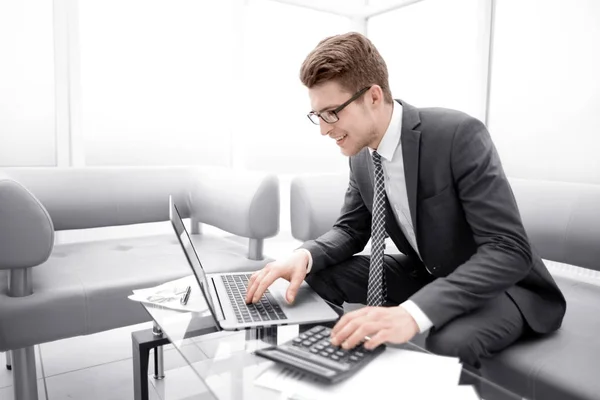 Fiatal üzletember számológép és laptop használata — Stock Fotó