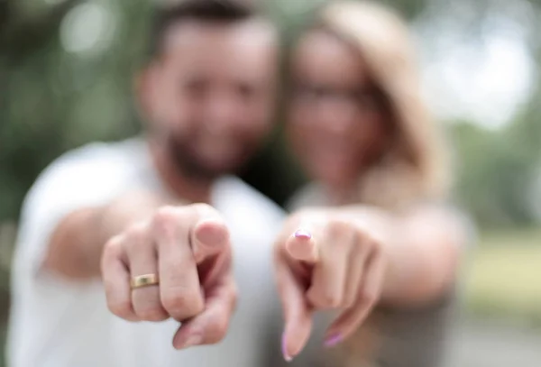 Happy married couple standing in the Park and pointing at you. — Stock Photo, Image